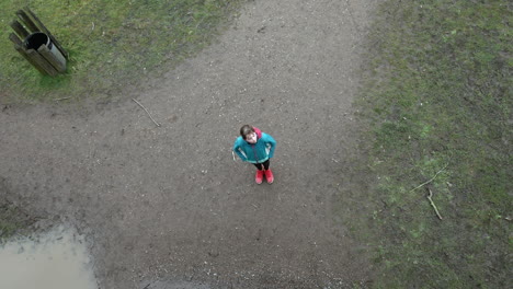 A-pensive-girl-looking-up-at-the-sky-and-closing-her-eyes-on-a-forest-past