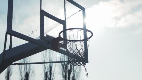 Close-up-fluid-gimbal-shot-of-basketball-hoop-sunlight