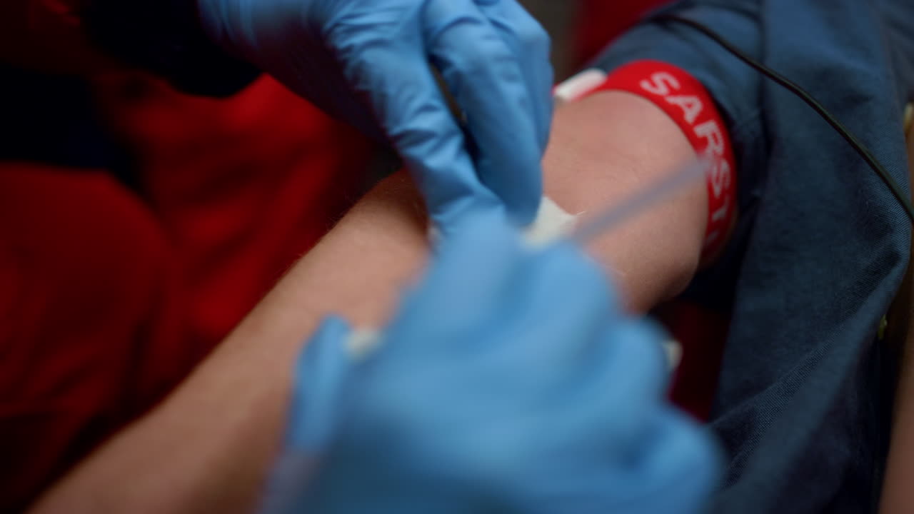 인식할 수 없는 간호사가 살균된 조직으로 남자의 팔을 문지르고 있습니다.