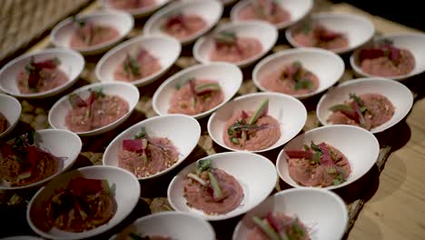 Fruit-and-foie-gras-appetizer-plates-on-tray,-Close-up-handheld-shot