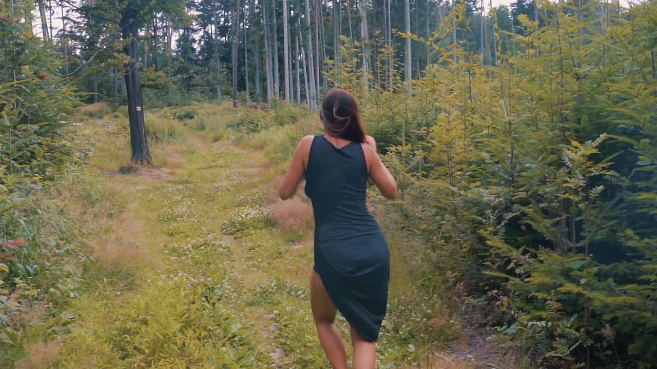 mujer bonita bailando en un bosque en cámara lenta