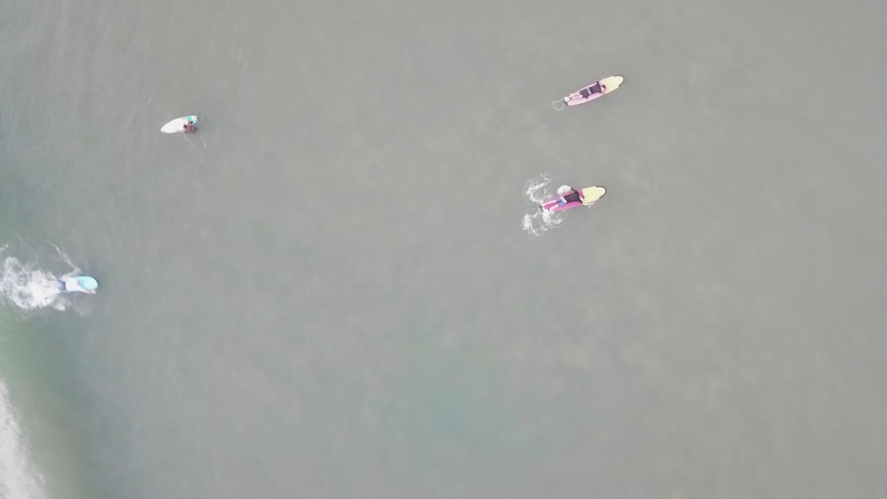 surfistas atrapando olas desde arriba