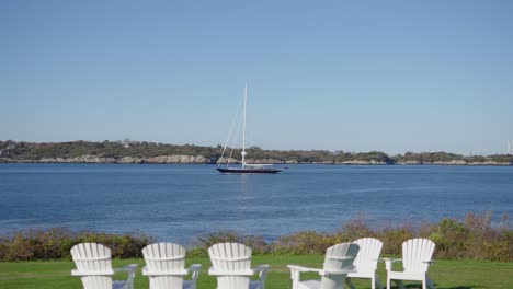 sailboat passing by in the ocean just offshore from a resort in newport rhode island