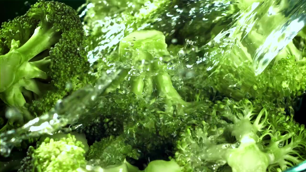 Cimette di broccoli fresche che vengono lavate con acqua al rallentatore