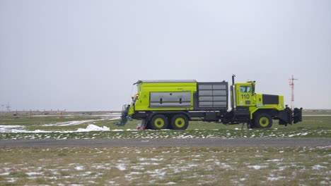 Quitanieves-De-Camión-Antihielo-Conduciendo-En-El-Aeropuerto,-Tiro-De-Seguimiento