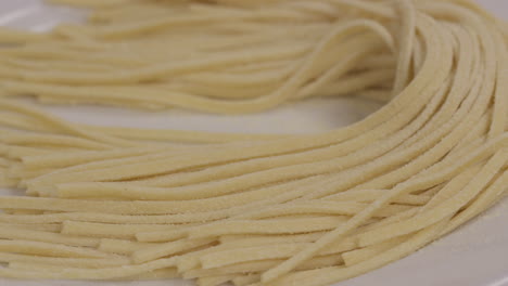 closeup of freshly cut pasta noodles placed on a plate before cooking