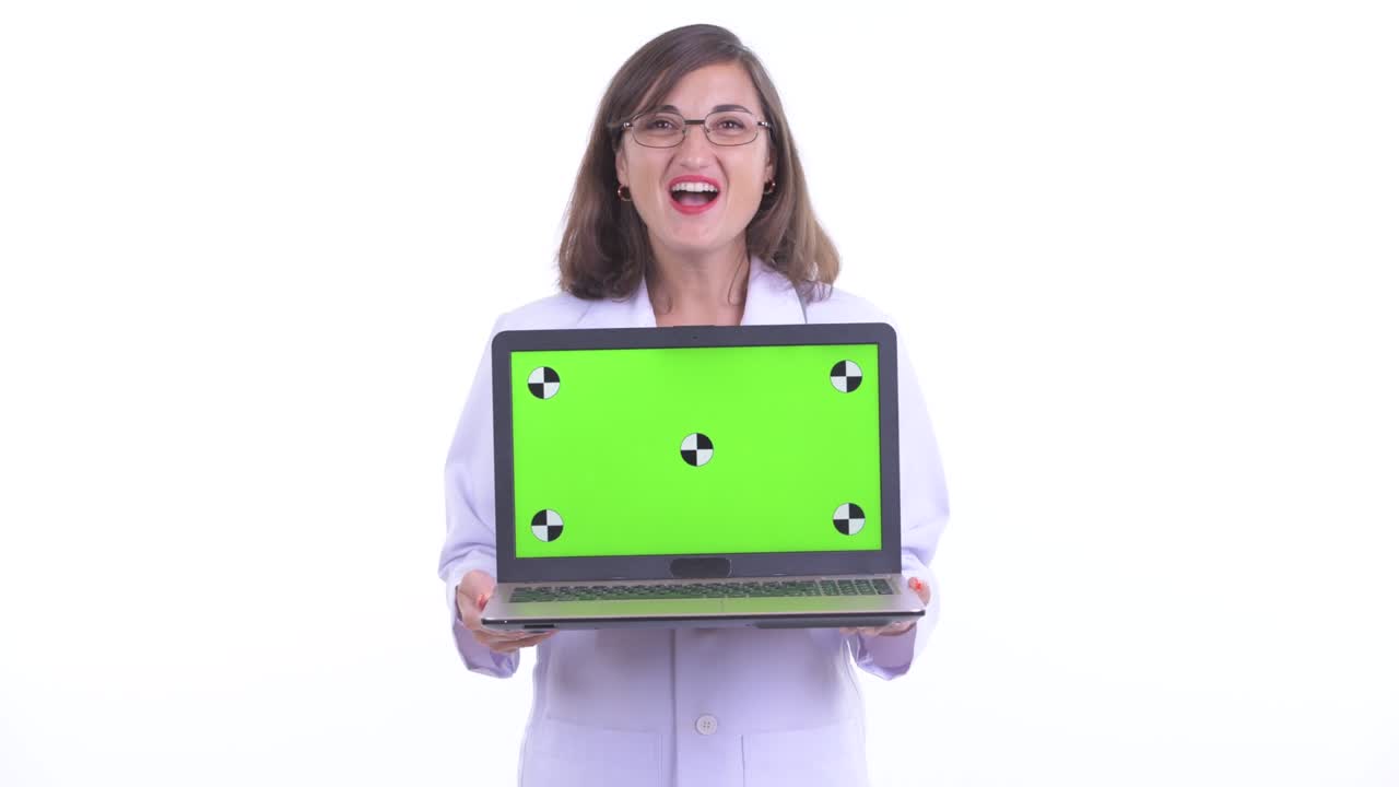 retrato de una doctora sonriendo y mostrando el espacio de copia de la tecla de croma de la pantalla del dispositivo portátil aislada contra un fondo blanco