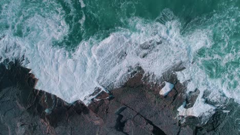 Waves-breaking-onto-rocks-aerial