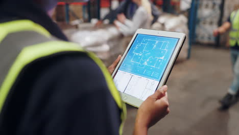 warehouse inspector reviewing blueprints on a tablet
