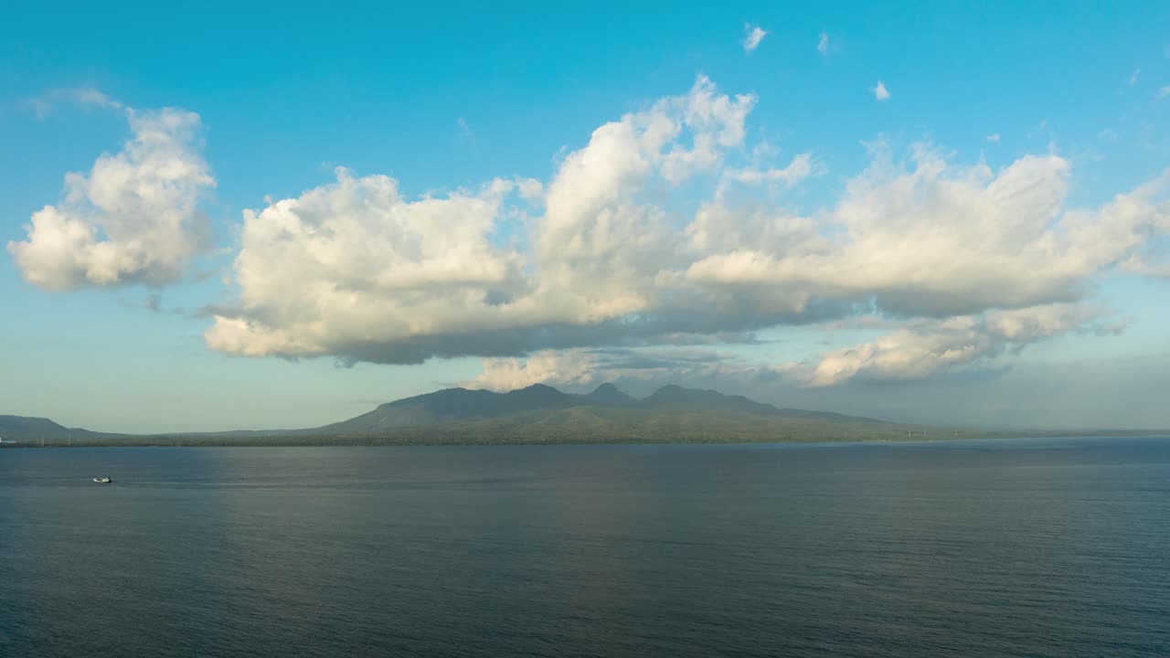 Timelapse aereo di nuvole che si muovono sullo Stretto di Bali e paesaggio montano.