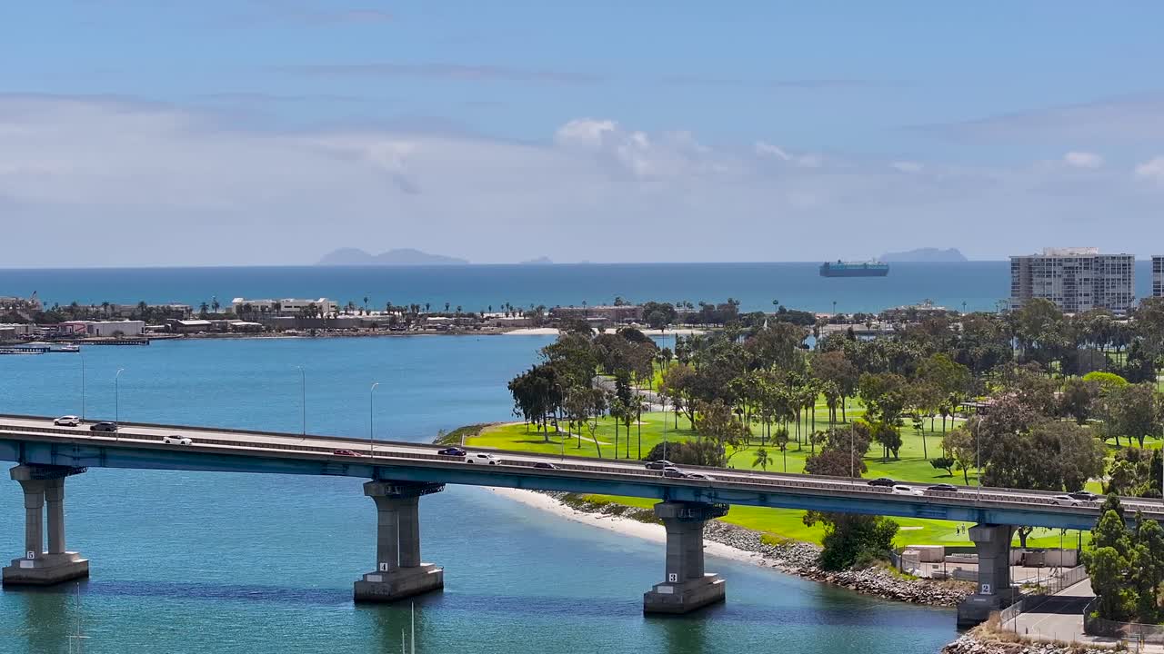 Aerial view of Coronado Bridge and Coronado Island in the background, sunny skies, 4K