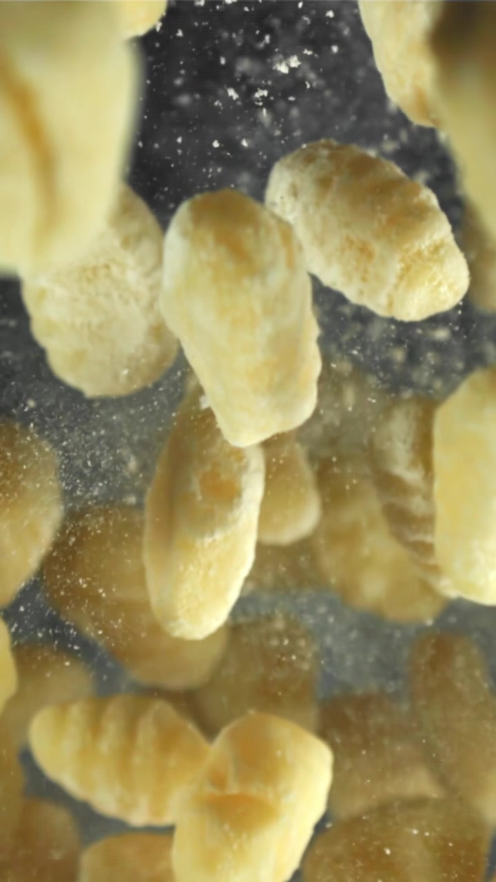 Gnocchi freschi che cadono al rallentatore con polvere di farina