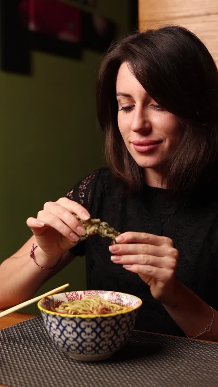 una mujer comiendo ramen.
