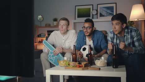 amigos viendo un partido de fútbol en casa