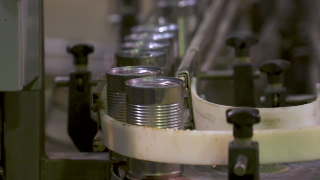 통조림 공장에서 생산 라인을 따라 이동하는 알루미늄 캔을 닫습니다.