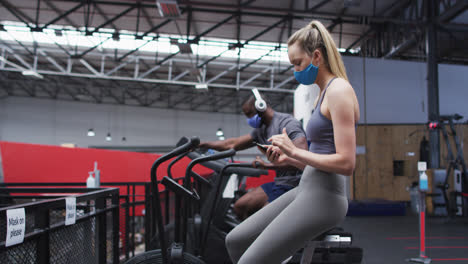 usar máscara facial usando el teléfono inteligente en el gimnasio