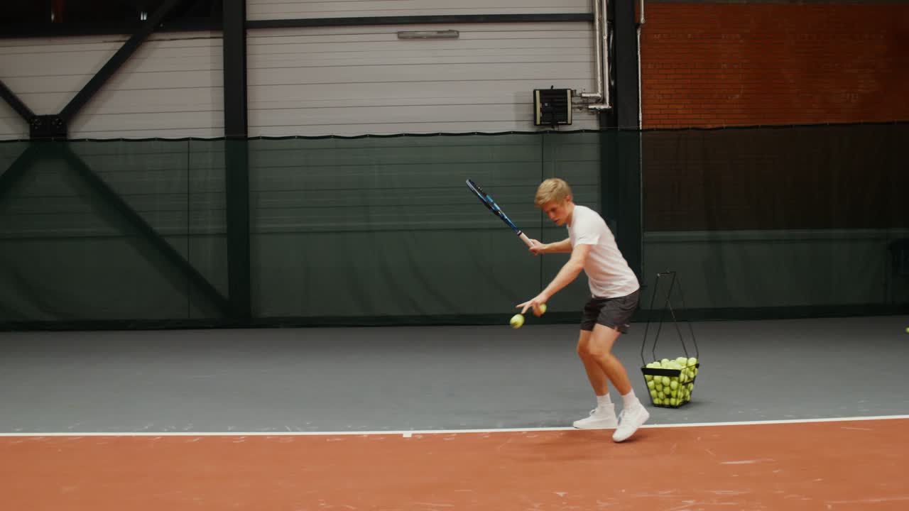 십대 테니스 선수 들 이 실내 코트 에서 훈련 하고 있다