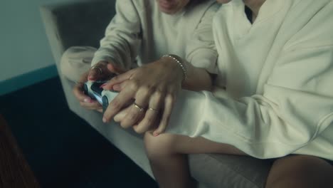 two women playing video games on a couch