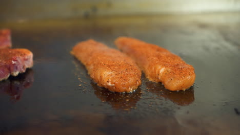 blackened catfish sizzles and steams on flat top griddle, slider slow motion 4k