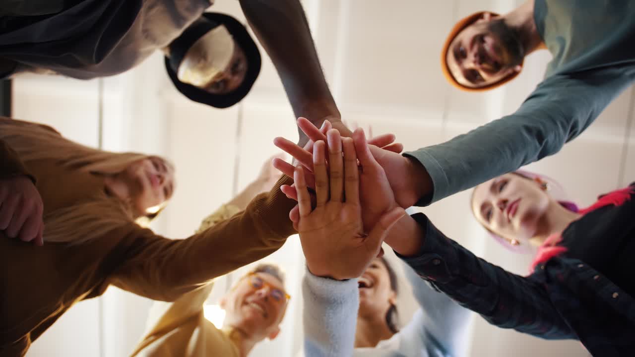 equipo multiétnico poniendo manos juntas uno por uno, conexión, creación de equipos y concepto de alianza, vista de abajo