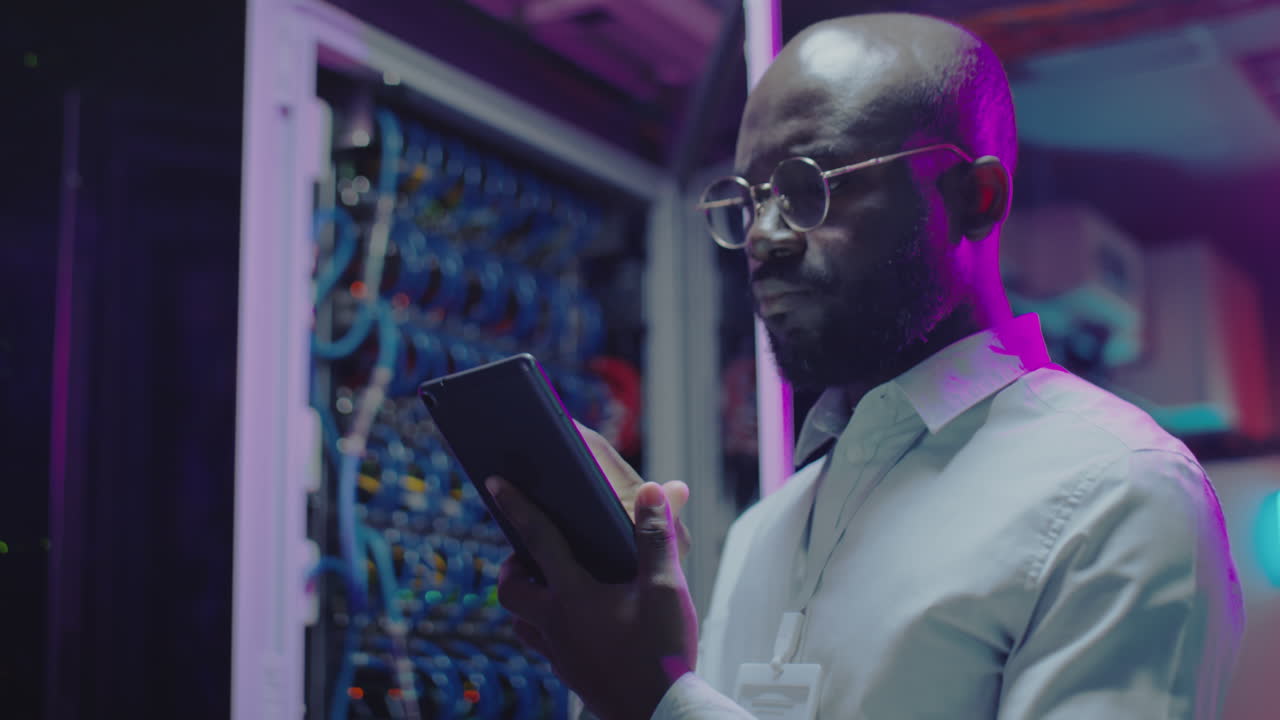 IT Technician Working with Tablet in Server Room