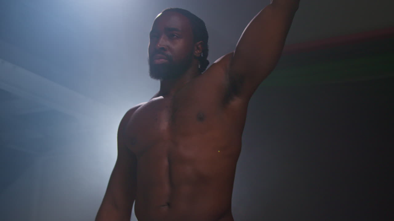 권투 선수가 장갑을 착용하고 권투 경기가 시작되기 전에 링에 들어와 팬들을 흔들고 인사합니다.