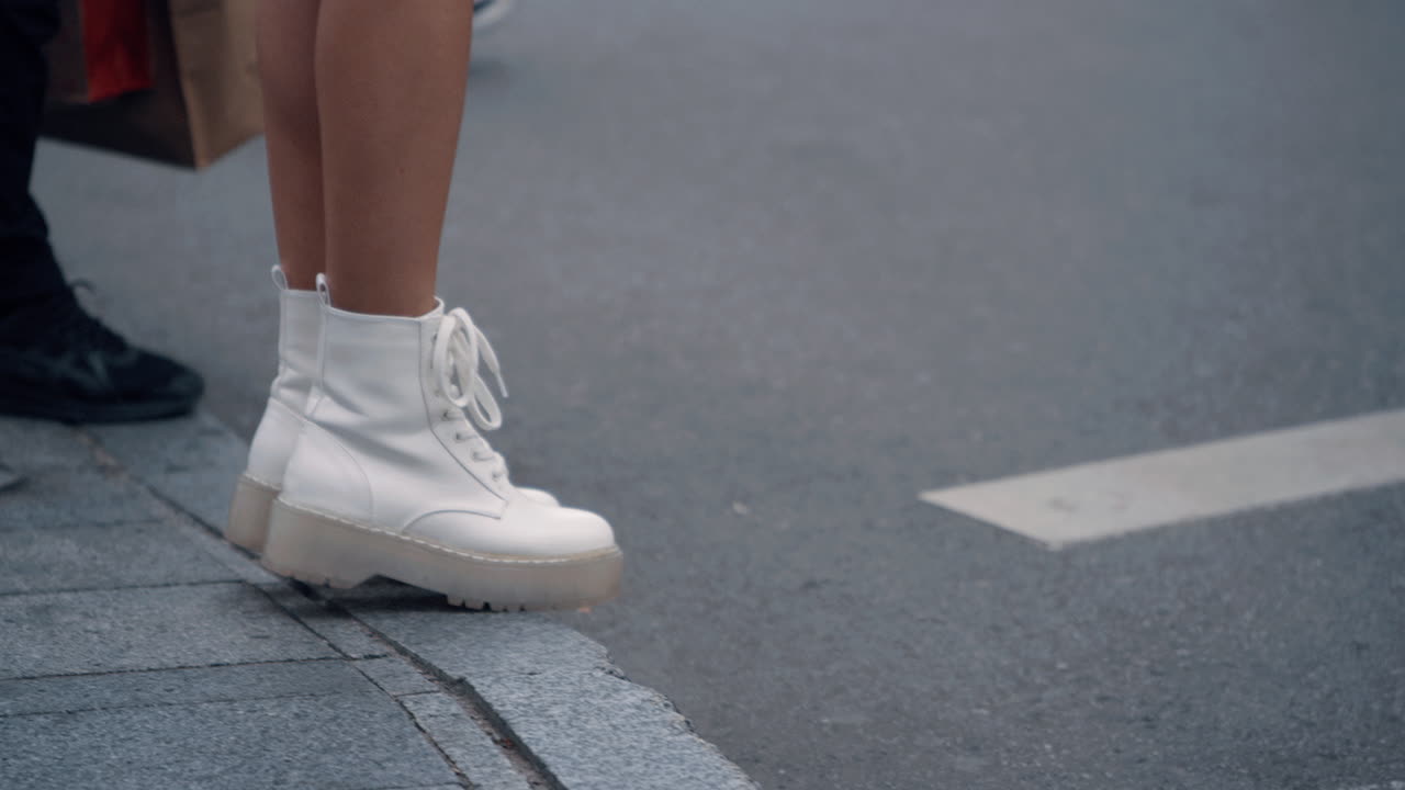 piernas femeninas caminando en una encrucijada en el paisaje urbano de fondo de la ciudad.