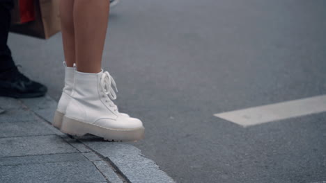 female legs walking crossroad in urban background city landscape.