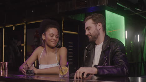 Multiethnic-Couple-Talking-Together-And-Taking-A-Selfie-Photo-While-Sitting-At-Bar-Counter