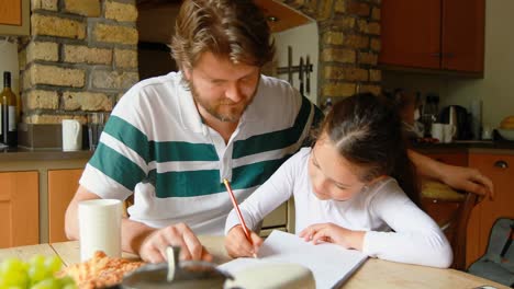 padre ayudando a su hija en los estudios en la cocina 4k