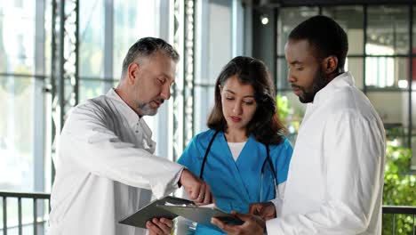 multi-ethnic male and female doctors talking in clinic