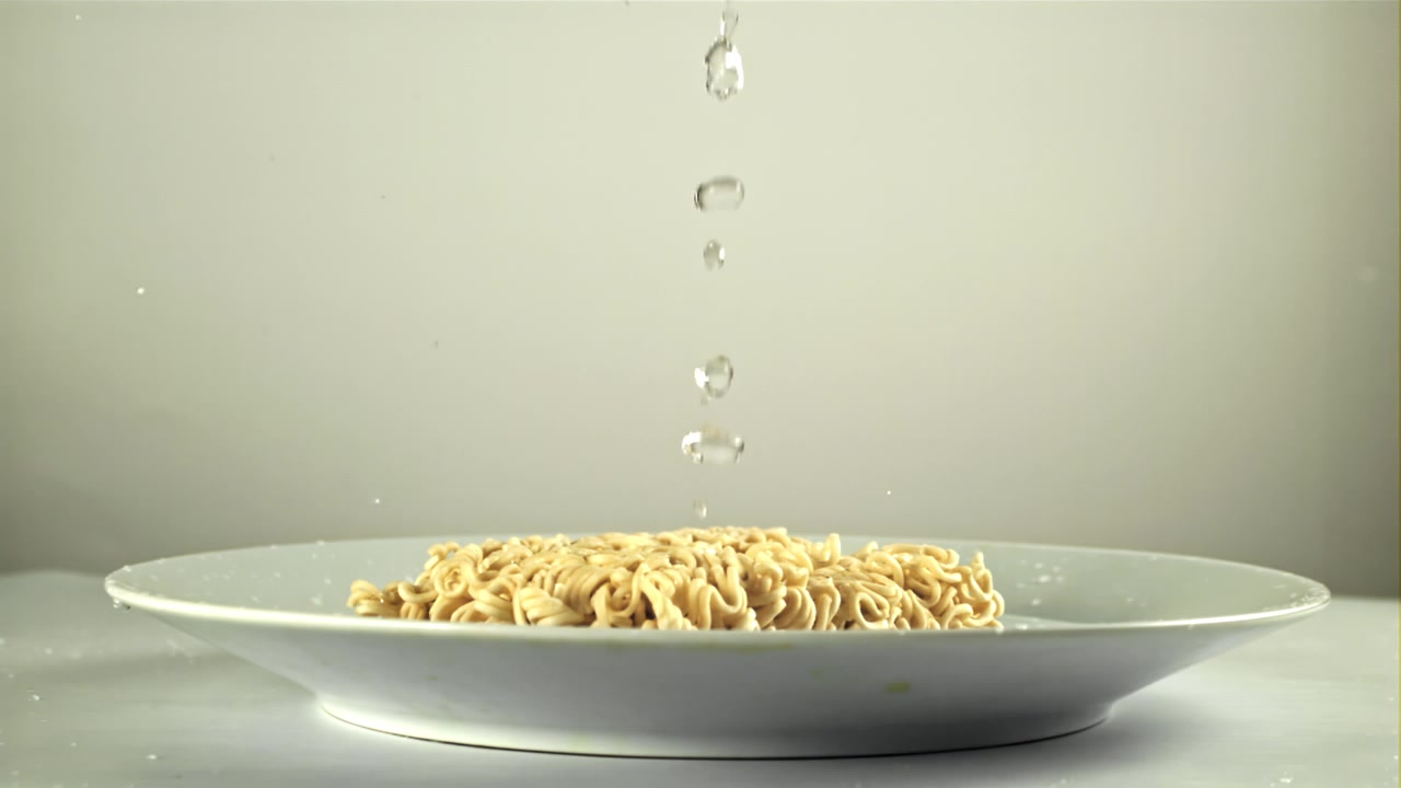 Slow Motion Water Droplets Falling on Dry Instant Noodles