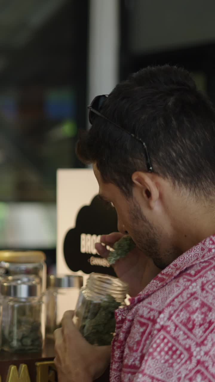 Man inspecting cannabis in a jar