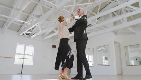 Caucasian-senior-couple-spending-time-together-in-a-ballroom-and-dancing