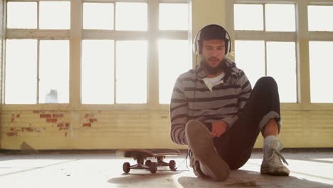 young man listening to music in empty warehouse