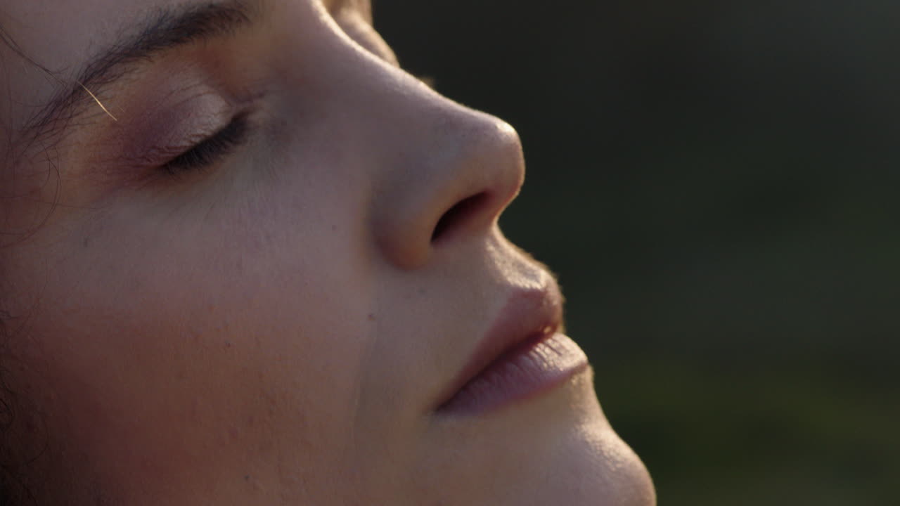 retrato en primer plano de una mujer hermosa disfrutando de una tranquila puesta de sol explorando la espiritualidad mirando hacia arriba orando contemplando el viaje con el viento soplando el cabello