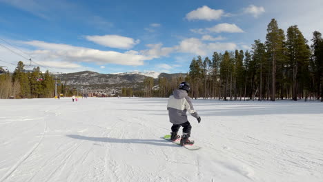 niño haciendo snowboard, en un día soleado, en breckenridge, colorado