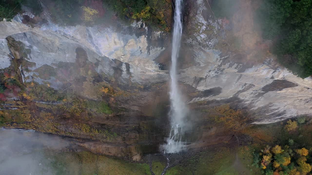 waterfall over the mountain rocks falling down on a bright day in Lauterbrunnen, Switzerland. Aerial footage