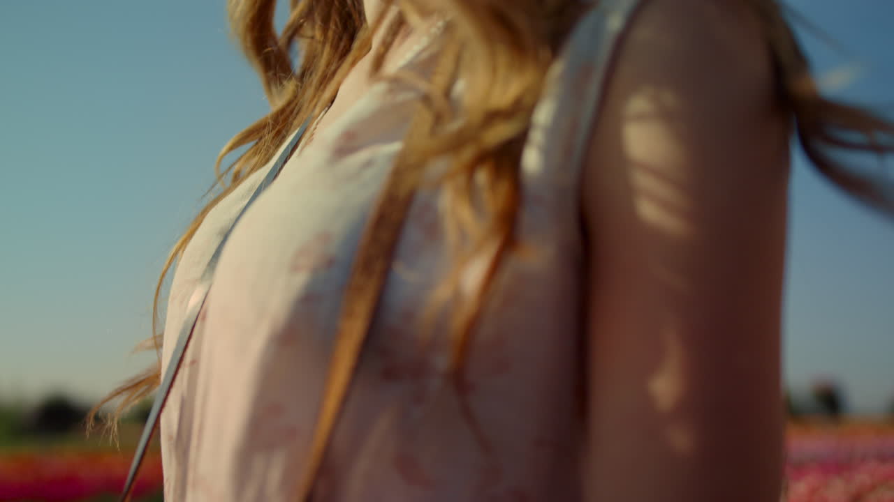 mujer en primer plano con cámara disfrutando de la luz del sol en un hermoso jardín con flores silvestres
