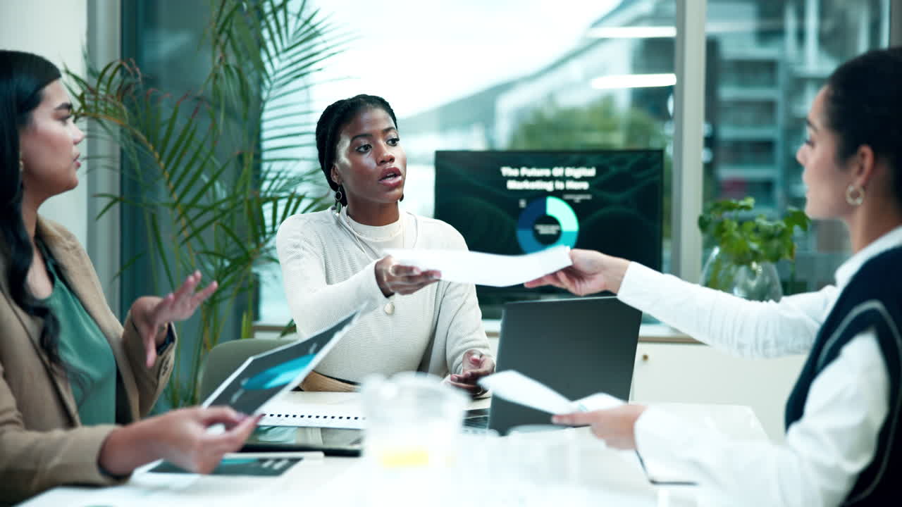 Businesswomen in a meeting reviewing documents