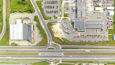 Aerial-top-down-view-of-the-big-logistics-park-with-warehouses,-loading-hub-and-a-lot-of-semi-trucks-with-cargo-trailers-awaiting-for-loading-unloading-goods-on-ramps