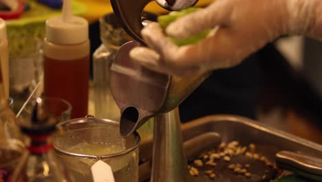 squeezing and pouring lime juice into a glass