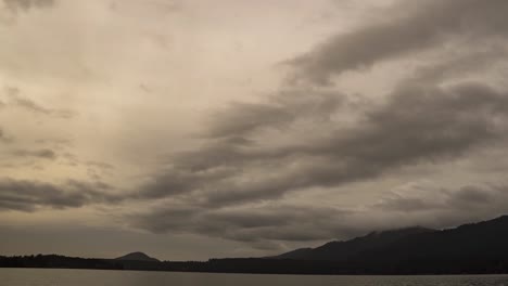dramatic gray storm clouds criss cross lake quinalt olympic national forest, zoom out pan right hyper lapse
