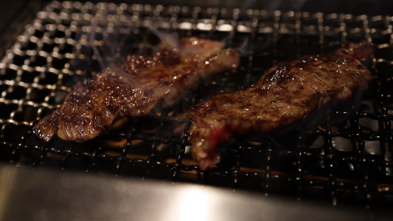 뜨거운 그릴에서 스테이크를 조리하고, 연기가 상승하고
