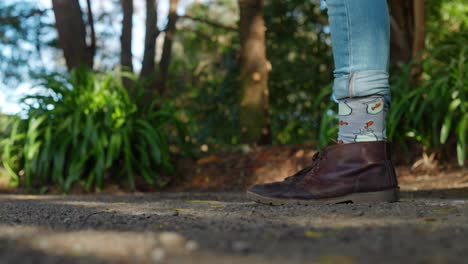 Ein-Kurzer-Videoclip-Einer-Person,-Die-Von-Den-Knien-Abwärts-Ins-Bild-Geht-Und-Lederstiefel-Und-Fischsocken-Trägt