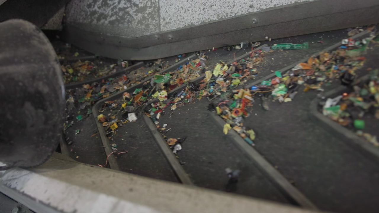 Shredded Circuit Fragments On Conveyor Belt, Multicolored Pcb Chips And Solder Flecks Sliding Between Rollers, . Media