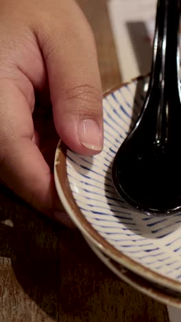 Hands arranging spoons and steamed buns
