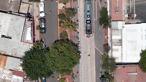 aerial view of a busy urban street with a passing train and pedestrians