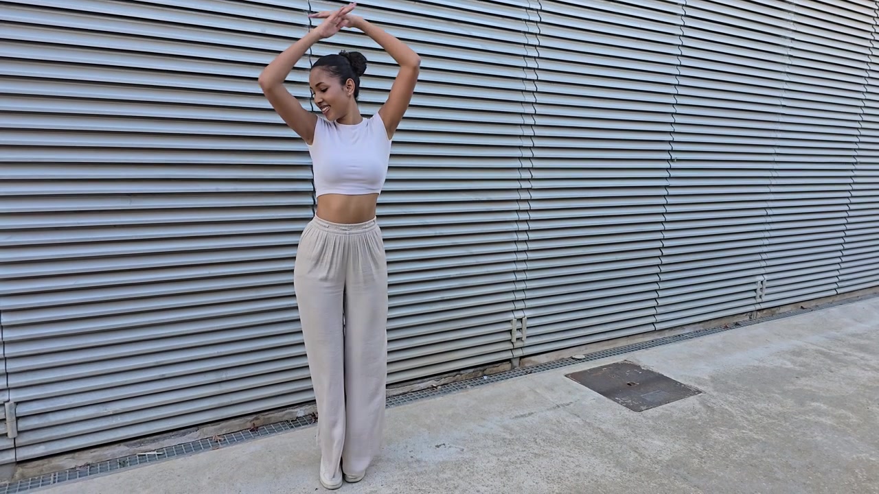 A trendy young woman elegantly posing against a modern architectural background scene