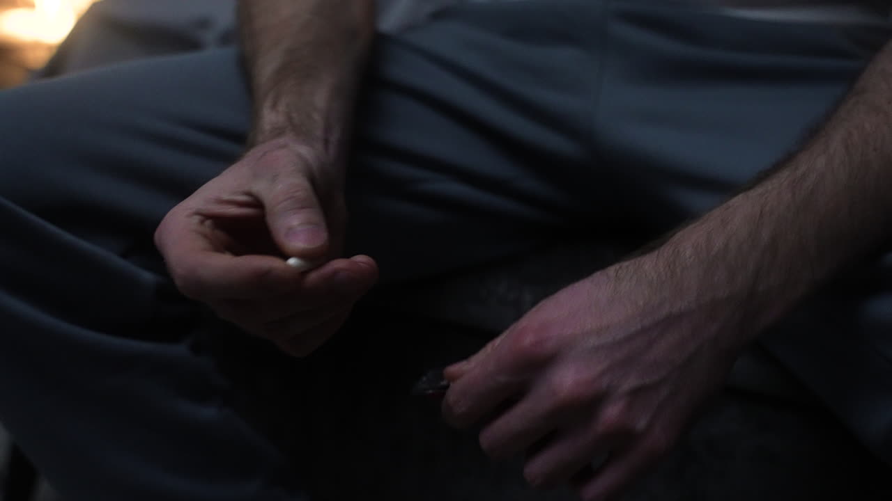 밤에 침대에 앉아 있는 남자